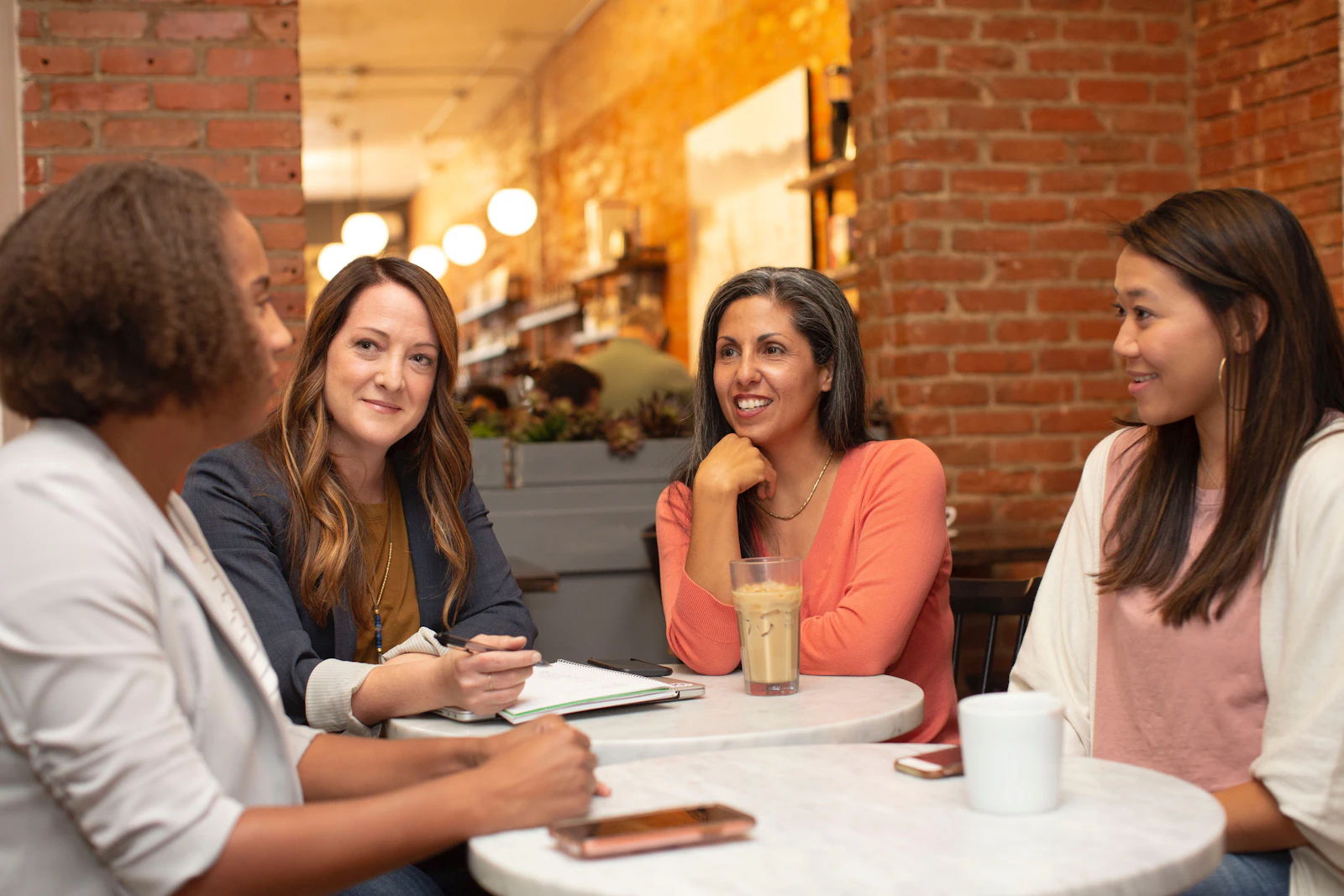 A diverse group of friends in genuine conversation over coffee